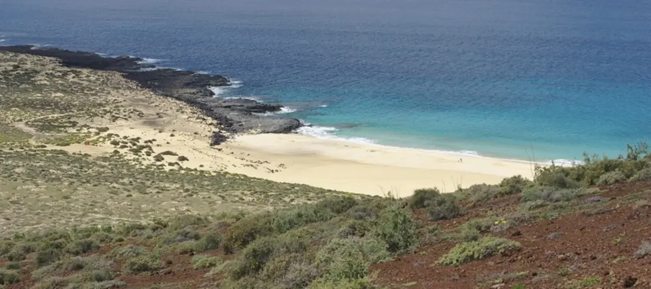 Sendero de tierra que lleva a la playa de Las Conchas en La Graciosa, con la imponente Montaña Bermeja al fondo.