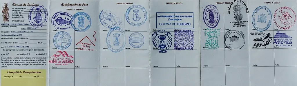 Credencial del peregrino abierta mostrando varios sellos del Camino de Santiago de Gran Canaria