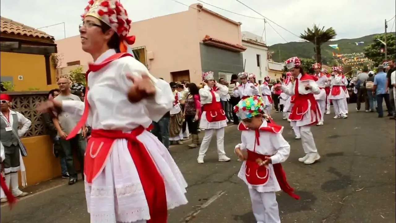 Bailarines con trajes típicos blancos y rojos durante la Bajada de la Virgen de los Reyes en El Hierro