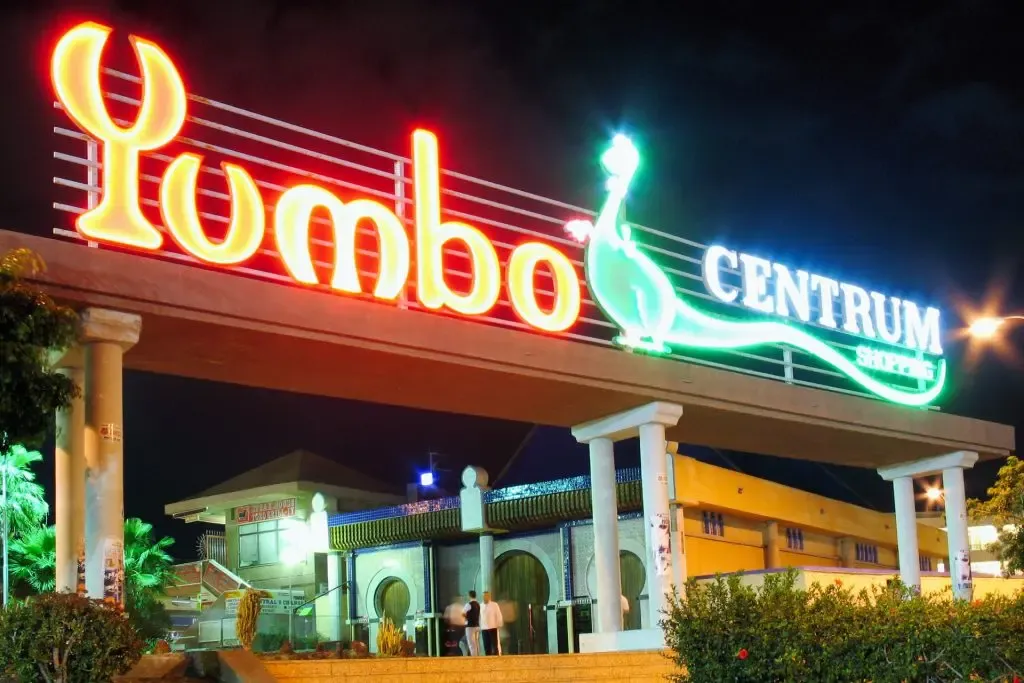 Centro Comercial Yumbo Centrum iluminado por la noche, con gente en terrazas y bares