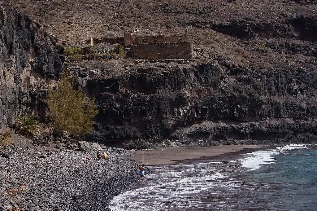 Vista espectacular de la playa virgen de Güigüí con arena negra y enormes acantilados