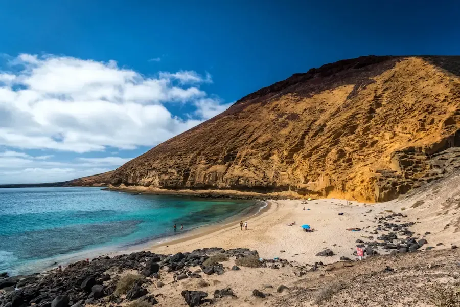 Vista aérea de la Playa de La Cocina bajo la Montaña Amarilla, con aguas esmeralda