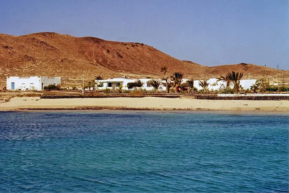 Playa del Salado en marea baja con piscinas naturales formadas entre rocas volcánicas