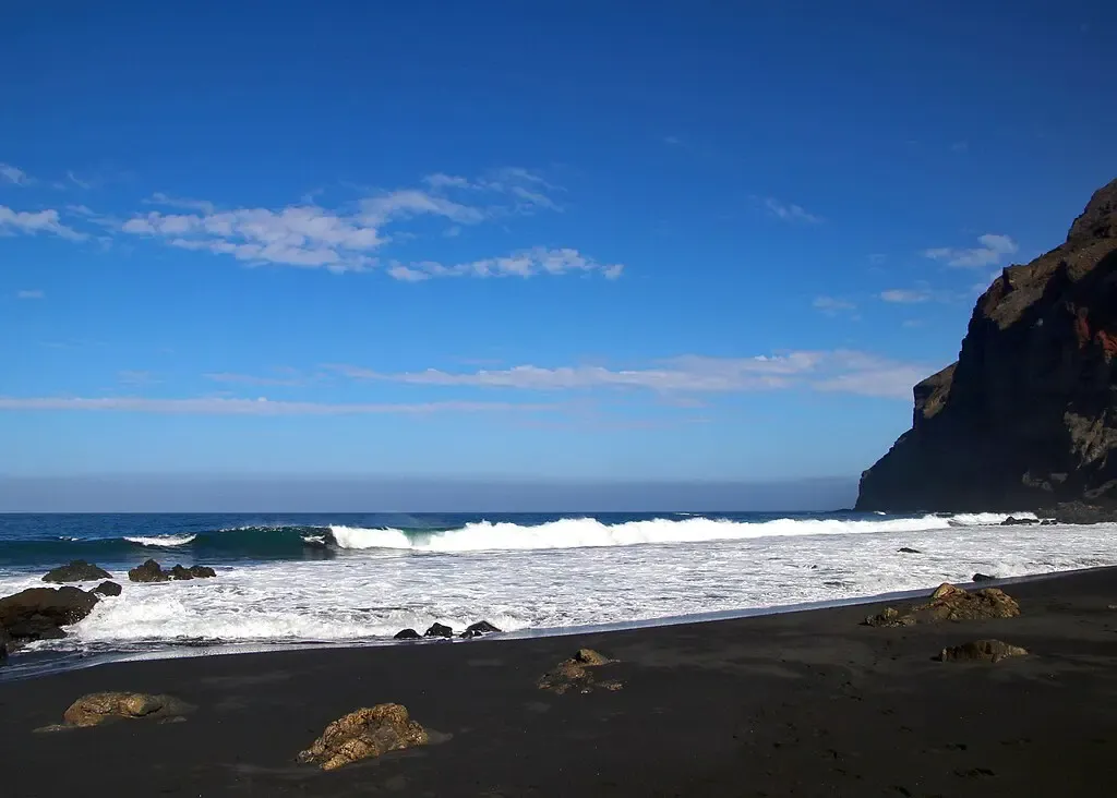Vista panorámica de la salvaje Playa del Inglés en Valle Gran Rey, con acantilados y arena negra