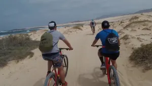 Imagen de Ciclista pedaleando por una pista de arena hacia la Playa de las Conchas