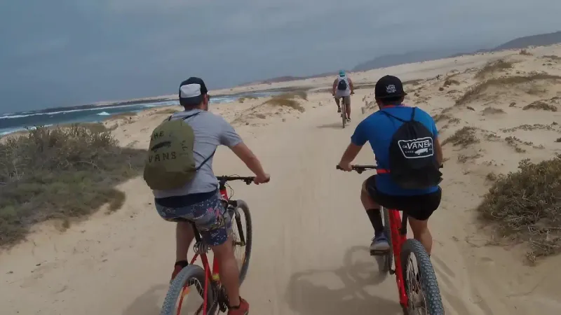 Imagen de Ciclista pedaleando por una pista de arena hacia la Playa de las Conchas