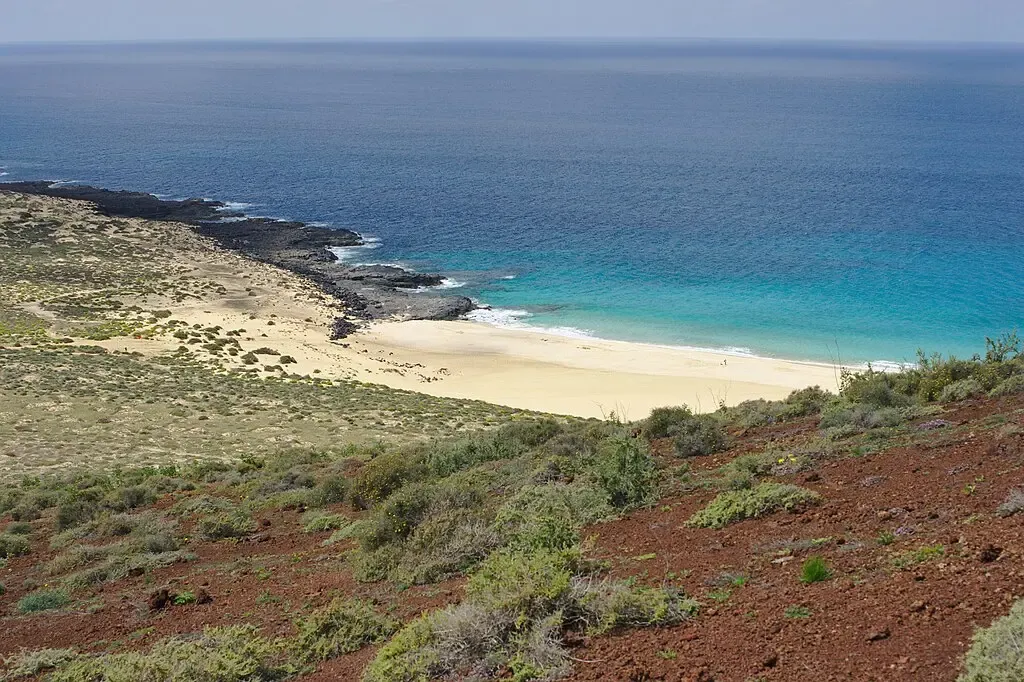 Persona caminando por un sendero de arena en La Graciosa hacia la Playa de las Conchas