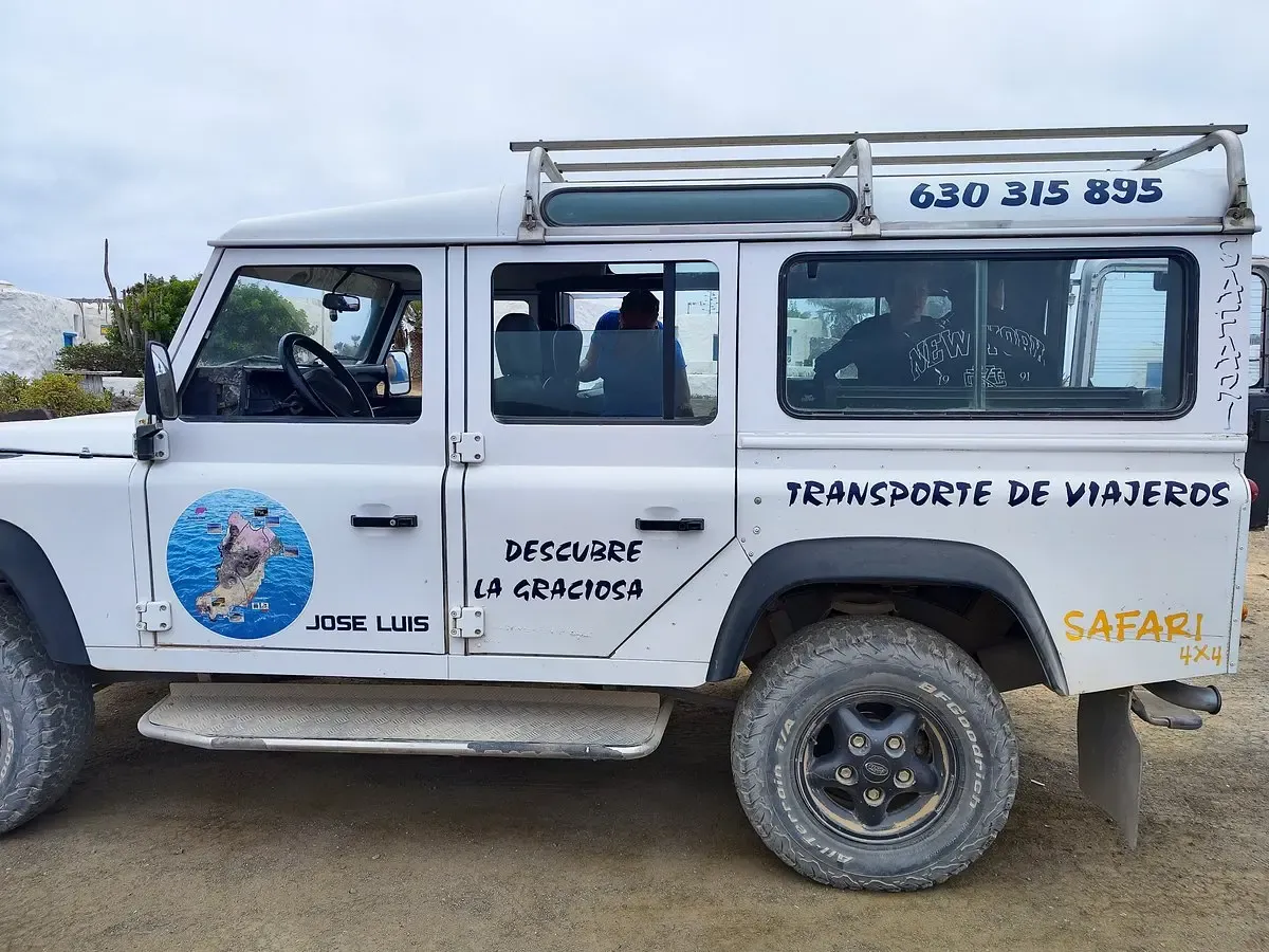 Un taxi jeep 4x4 blanco circulando por una pista de arena en La Graciosa