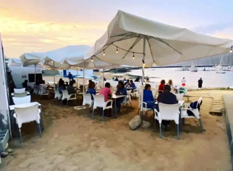 Terraza de un restaurante concurrido en el puerto de Caleta de Sebo, con vistas al mar
