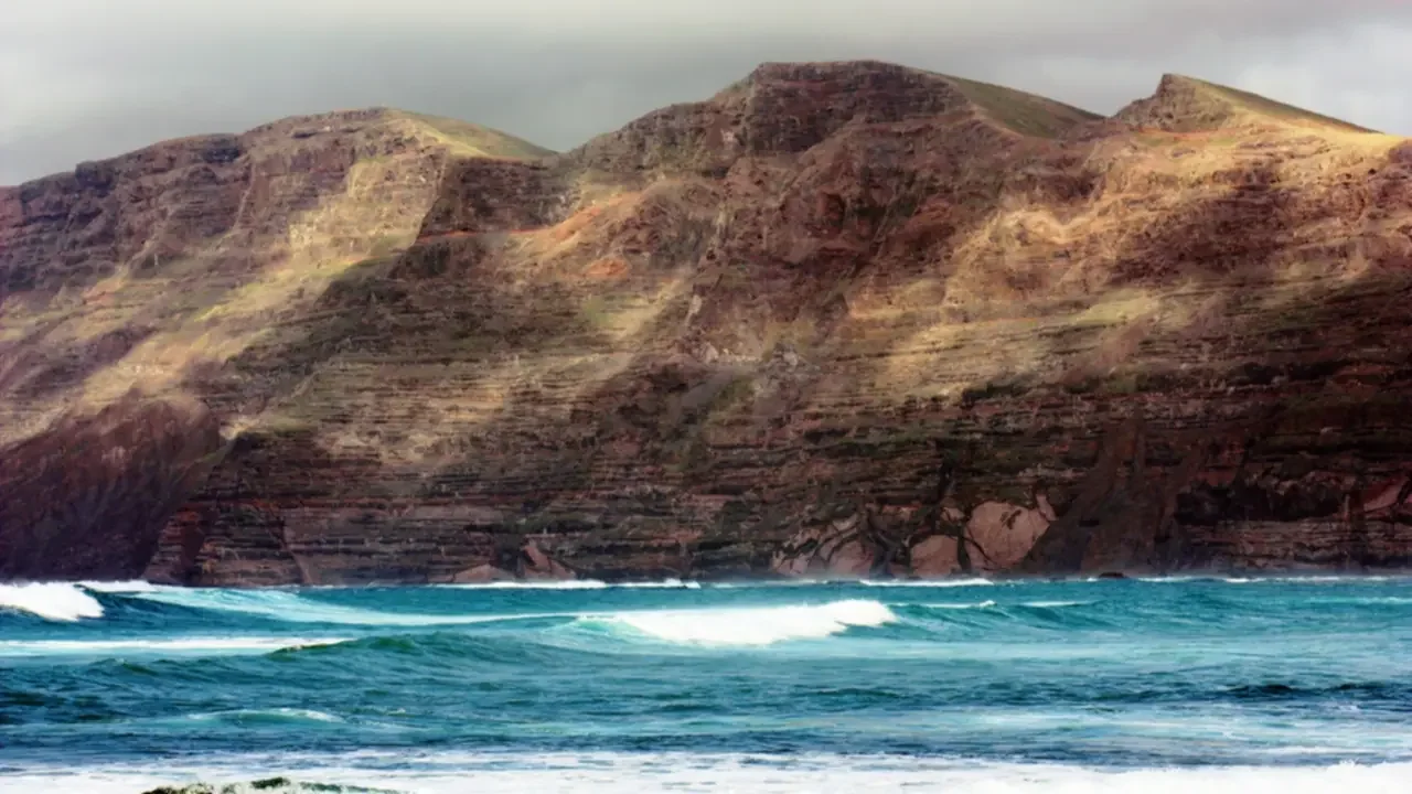 Las imponentes vistas del Risco de Famara en Lanzarote desde la orilla de la Playa de La Cocina, en La Graciosa.
